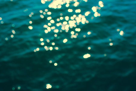Defocused sea texture. Turquoise sea water with sun glare and ripple. Powerful and peaceful nature conceptの写真素材