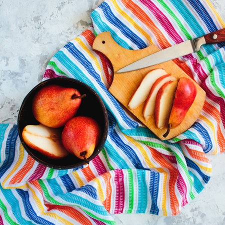 Overhead bright red williams pears on multi color striped textile backgroundの写真素材