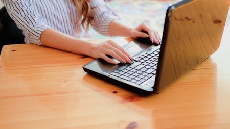 Woman typing on laptop in office. Female digital working.の写真素材