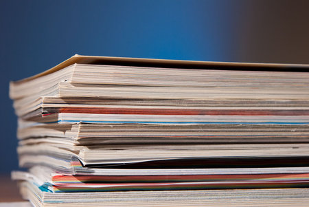 magazines on a desk isolated over a blue backgroundの写真素材