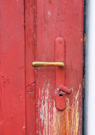 Old handle with old doors with damaged red colorの写真素材
