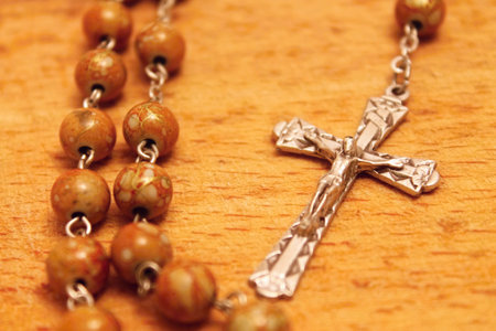 Rosary with crucifix on the wooden board の写真素材