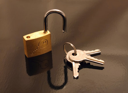 Opened padlock and three keys on black backgroundの写真素材