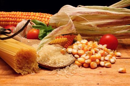 Wooden table with different kinds of pasta and vegetableの写真素材