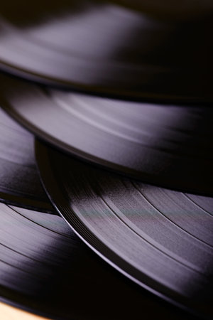 Vertical photo of several black LP records which are placed on table over each other.の写真素材