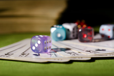 Horizontal photo of used playing cards with flush. Few dices are placed on cards and one transparent...
