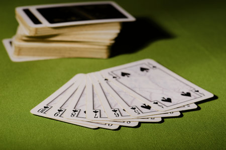 Horizontal photo of used cards placed on green carpet. The cards are there with flush and the rest is in pack in background.の写真素材