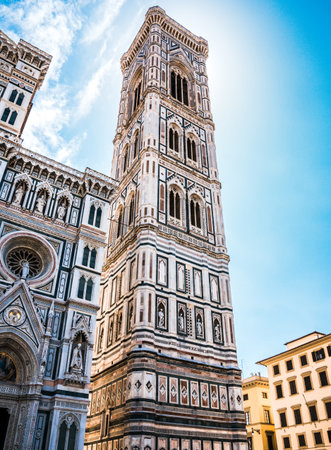 Vertical photo with famous tower Campanile di Giotto. Tower has colorful surface with statues and big bell. The tower is built in town Florence in Italy Tuscany.の写真素材