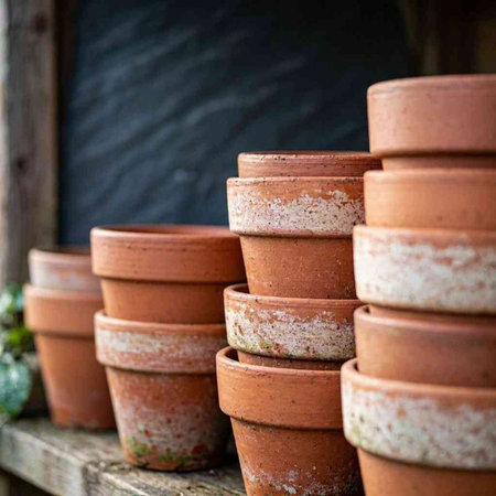 Clay pots on the shelf in the garden. Vertical photo.