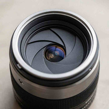 Camera lens with reflection on a grey background. Close-up.