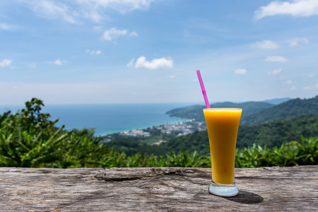 Fresh mango juice with nice view at the top of mountainの写真素材