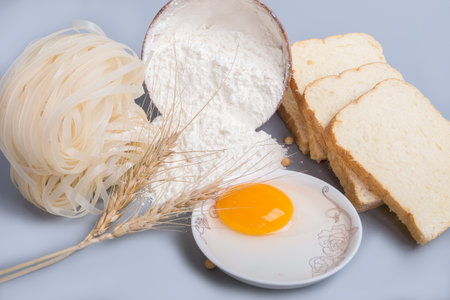 flour, egg, noodles and bread on tableの写真素材