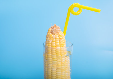 corn in a cup of water with a strawの写真素材