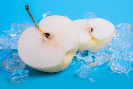 pears with ice cubes on blue backgroundの写真素材