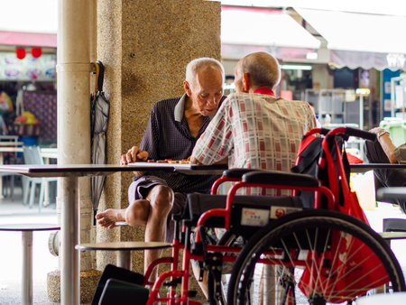 SINGAPORE, 12 APR 2019 - Two old male pensioners / retirees enjoy a game of Chinese chess in a hawker centre. Singapore has a rapidly aging populationのeditorial素材
