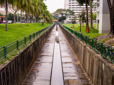 Tree lined water canal channel in a HDB residential housing estate in Singapore. の写真素材