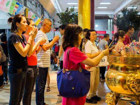 SINGAPORE, 18 MAY 2019 - Devotees pray and offer incense to Buddha on Vesak Day at Bright Hill temple in Singapore. Vesak Day is a festival which commemorates the birth and enlightenment of Buddhaのeditorial素材