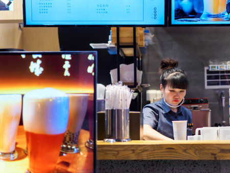 TIANJIN, CHINA - 7 OCT 2019 - A bubble tea stall employee within a shopping mall preparing a drink for customers. Food & beverage / consumer culture themeのeditorial素材
