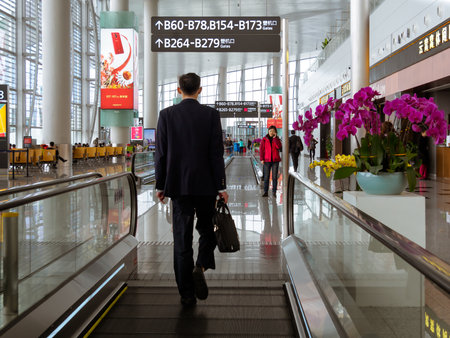 BAIYUN, GUANGZHOU, CHINA - 10 MAR 2019 â Back view of a traveller in business suit walking towards his boarding gate at Baiyun International Airport. Baiyun is one of the busiest airports in China.のeditorial素材