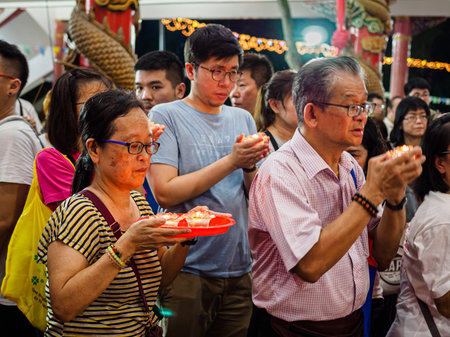 SINGAPORE, 18 MAY 2019 - Devotees offer lit oil lamps to Buddha on Vesak Day at Bright Hill temple in Singapore. to commemorates the birth and enlightenment of Buddha. Oil lamps symbolise wisdom and enlightenment in Buddhismのeditorial素材