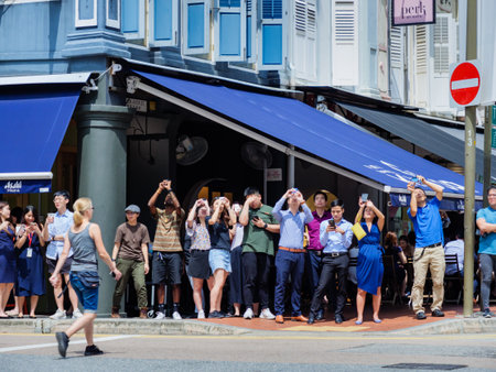 SINGAPORE â 26 DEC 2019 â  Crowd of onlookers in the Central Business District (CBD) watch the âring of fireâ solar eclipse; take photos and sharing on social mediaのeditorial素材