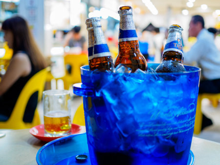 SINGAPORE - 17 MAR 2019 - Bottles of Tiger beer sit in a bucket of ice at a coffeeshop / kopitiam / hawker centre. Drinking beer at a coffeshop is common practise in Singaporeのeditorial素材