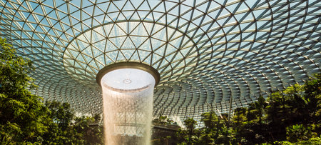 SINGAPORE â 23 MAR 2020 - Panorama of the HSBC rain vortex indoor waterfall at Jewel mall, Changi airport, Singapore. The waterfall is surrounded by a terraced forest.のeditorial素材