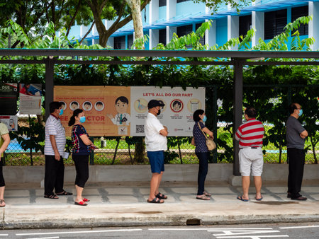 SINGAPORE â€“ JULY 10 2020 â€“ Elderly Singaporean voters wearing protective masks and...