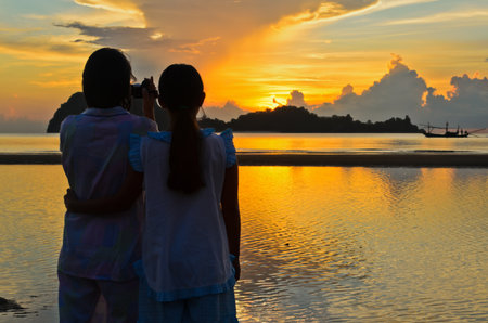 Mother and daughter are very happy to shoot the sunrise の写真素材