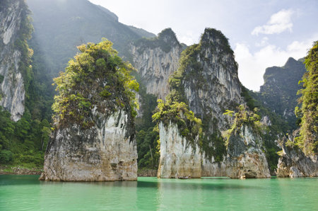 Beautiful high mountains and green river in the morning at Ratchaprapha Dam, Khao Sok National Park,...