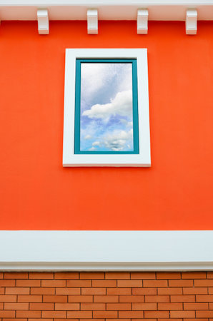 Sky and cloud reflection in window glass on orange wall of house, Italy retro styleの写真素材