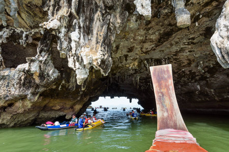 PHANG NGA THAILAND  APRIL 27 2015: Happy tourists on canoe through the caves of the island on the sea surface at Tham Lod cave in Ao Phang Nga Bay National Park APRIL 27 2015 in Thailandのeditorial素材