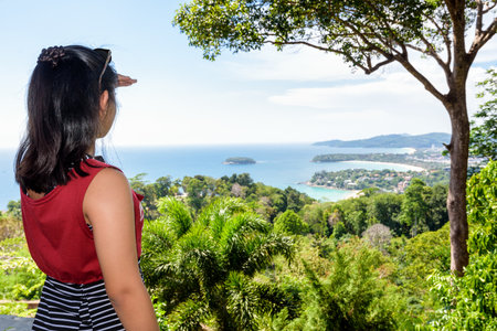 Woman tourist on high scenic view for looking beautiful landscape three beach and sea at Hat Kata Karon Viewpoint in Phuket island, Thailandの写真素材