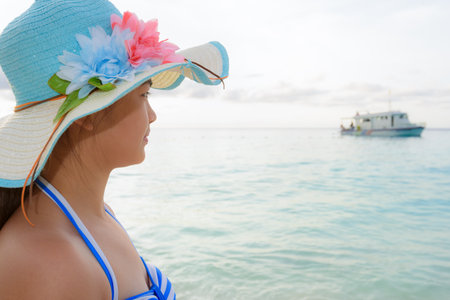 Half portrait teenage girls in a blue swimsuit looking beautiful nature of sea during sunrise with happiness on beach at Koh Miang Island, Similan National Park, Phang Nga, Thailandの写真素材