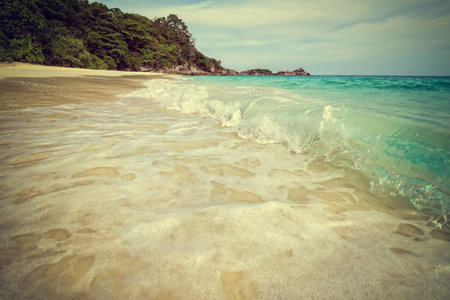 Vintage green tone style add texture effect beautiful landscape sky over the sea and waves on beach in summer at Koh Miang island, Mu Ko Similan National Park, Phang Nga province, Thailandの写真素材