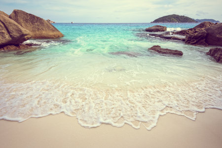 Vintage style beautiful nature of blue sea sand and white waves on small beach near the rocks during summer at Koh Miang island in Mu Ko Similan National Park, Phang Nga province, Thailandの写真素材