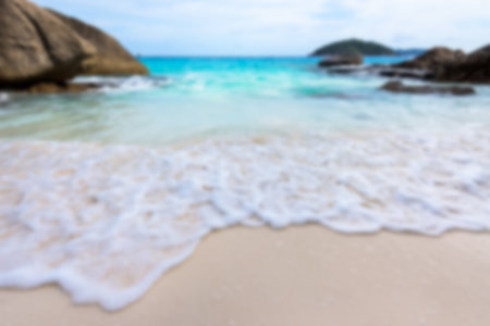 Blurred photograph for background, beautiful nature of blue sea and waves on beach between rocks...