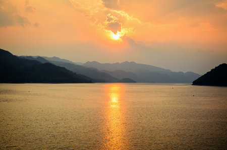 Beautiful landscape during sunset over a mountain ranges at lake in Srinakarin Dam, Kanchanaburi Province, Thailandの写真素材