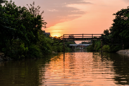 Landscape small canals, water is used as a thoroughfare rural and old wooden bridge for crossing the water during sunset in Phra Nakhon Si Ayutthaya Province, Thailandの写真素材