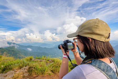 Hiker asian teens girl with backpack looking photo on digital camera is beautiful landscape natural...