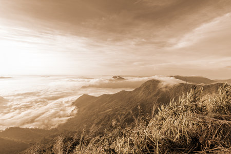 Vintage sepia color style, Beautiful landscape nature of sunrise on the clouds view from peak mountain with sun mist and bright sky at Phu Chi Fa Forest Park is a famous attractions of Chiang Rai, Thailandの写真素材