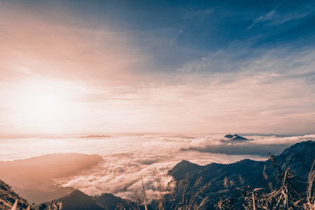 Vintage style in Sienna-Blue color two tone, beautiful landscape nature of sunrise on peak mountain with cloud fog and sky in winter at Phu Chi Fa Forest Park, Chiang Rai Province, Thailandの写真素材