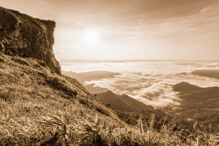 Vintage sepia color style, Beautiful landscape nature of sunrise on the clouds view from peak mountain with sun mist and bright sky at Phu Chi Fa Forest Park is a famous attractions of Chiang Rai, Thailandの写真素材