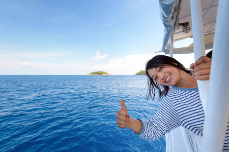 Tourist woman smiling happily with thumb up praising the beautiful of the sea at Mu Koh Similan island National Park, Phang Nga Province, Thailandの写真素材