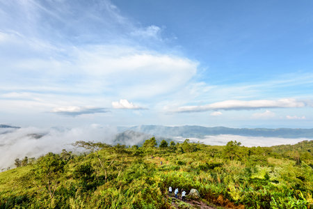 Tourists are walking on nature trails amidst the beautiful landscape of mountain range sky cloud and fog in the winter at Phu Chi Fa Forest Park, Chiang Rai Province, Thailandの写真素材