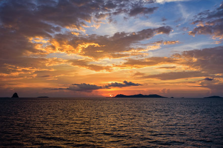 Beautiful natural landscape of colorful cloud sky and sun at sunset over the sea in Surat Thani province, Thailandの写真素材