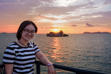 Beautiful nature of colorful sky and sun at sunset over the sea, women tourist on the deck of a large passenger boat while cruising to Koh Samui Island in Surat Thani province, Thailandの写真素材