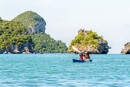 Two women are mother and daughter. Travel by boat with a kayak around island enjoy view the beautiful natural landscape of the blue sea at summer, Mu Ko Ang Thong National Park, Surat Thani, Thailandの写真素材