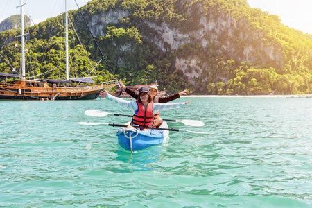 Two women are mother and daughter. Travel by boat with a kayak happy on the sea under the bright summer sky front of Ko Wua Ta lap islands at Mu Ko Ang Thong National Park, Surat Thani, Thailandの写真素材