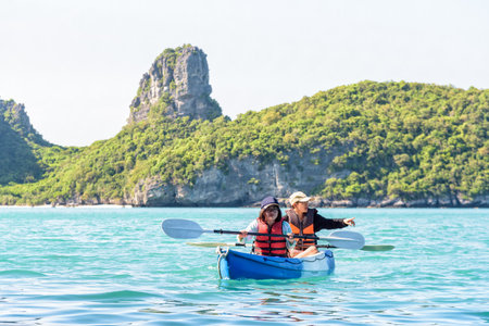 Two women are mother and daughter. Happy family travel by kayak around Ko Mae Ko view the beautiful nature of the sea and island during summer at Mu Ko Ang Thong National Park, Surat Thani, Thailandの写真素材
